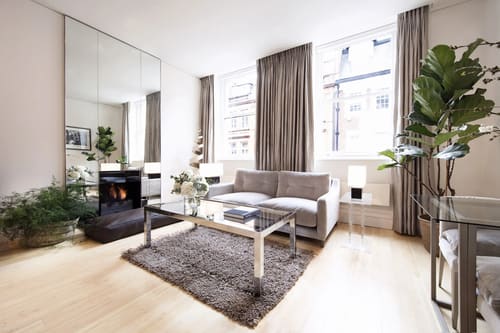 Maddox Street Apartments, Mayfair: Living room with fireplace and grey sofa