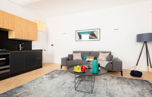Royal Albert Apartments, Kensington: Living room with grey sofa and open kitchen