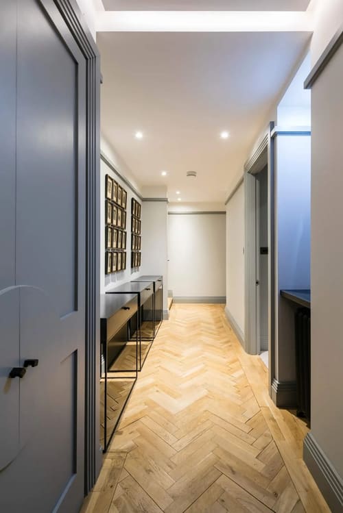 Prime Mayfair 1 bedroom no.3, W1K, Mayfair: Corridor with framed prints and herringbone floor