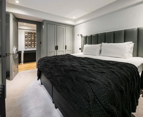 Prime Mayfair 1 bedroom no.3, W1K, Mayfair: Bedroom with black knitted throw and panelled wardrobes