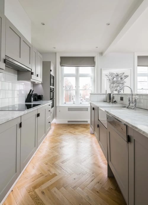Prime Mayfair 3 bedroom Apartment, Mayfair: Galley kitchen with grey units and herringbone floor