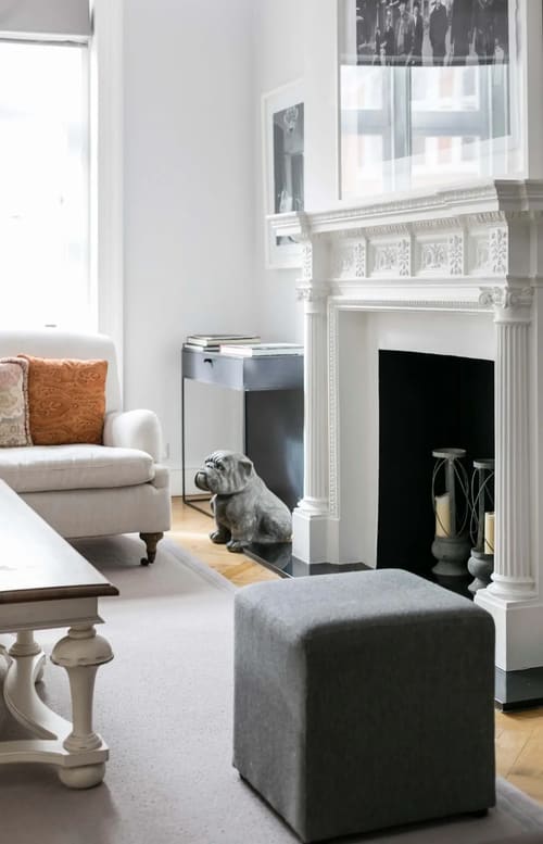 Prime Mayfair 3 bedroom Apartment, Mayfair: Armchair beside a fireplace with a dog sculpture