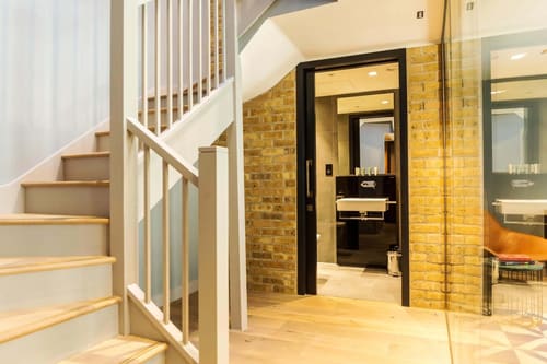 The Bankside Apartments, East London: Staircase leading to an exposed-brick hallway