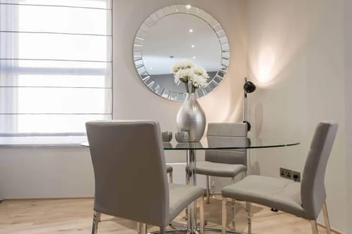 One Harrington Gardens, Kensington: Dining table beneath a round mirror