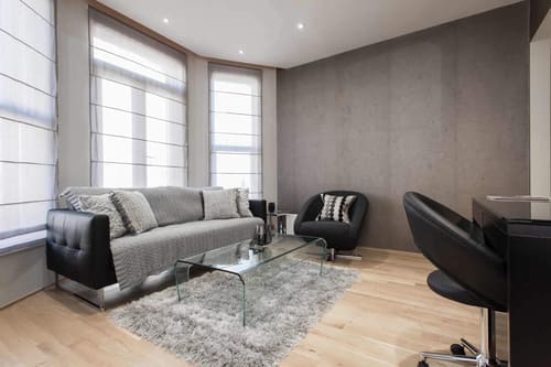 One Harrington Gardens, Kensington: Living room with grey sofa and black armchairs