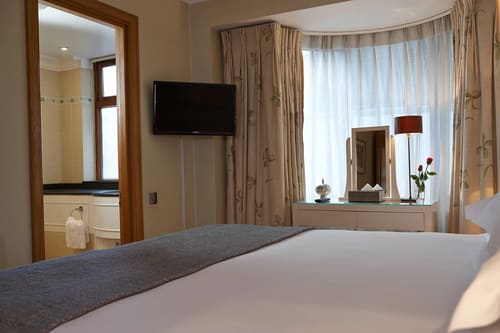 Cheval Knightsbridge, Knightsbridge: Bedroom with bay window and wall-mounted TV