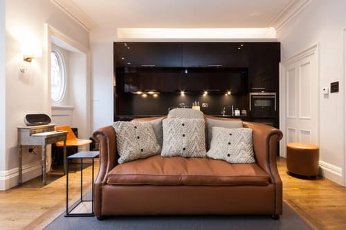 Prime Mayfair 1 bedroom no.1, W1K, Mayfair: Leather sofa in front of a dark kitchen