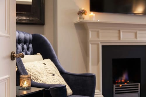 Prime Mayfair 1 bedroom no.1, W1K, Mayfair: Navy velvet armchair beside a fireplace