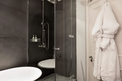 Prime Mayfair 1 bedroom no.2, W1K, Mayfair: Shower room with dark tiles and bathrobes