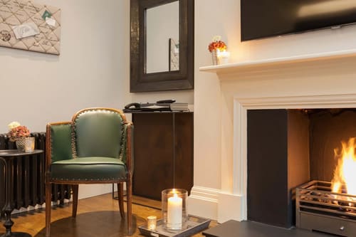 Prime Mayfair 1 bedroom no.2, W1K, Mayfair: Green leather armchair by a fireplace
