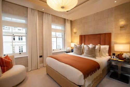Prince of Wales Long Term Apartments, Kensington: Double bedroom with rust headboard and tall windows