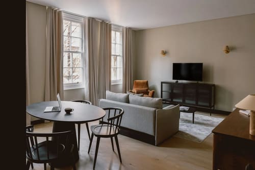 The St Paul’s Apartments, East London: Living room with grey sofa and round dining table