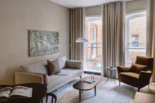 The St Paul’s Apartments, East London: Living room with grey sofa and tall windows