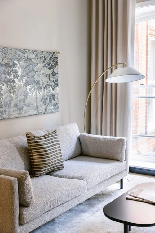 The St Paul’s Apartments, East London: Grey armchair with floor lamp and botanical print