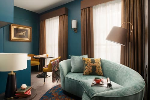 The Other House Apartments, Kensington: Teal living room with curved mint sofa