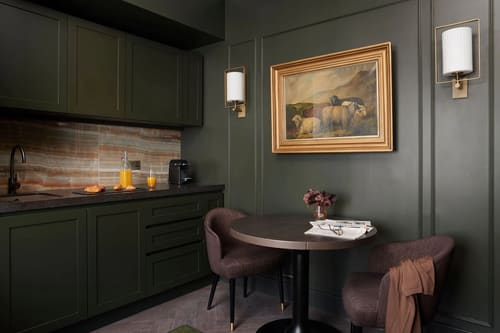 The Other House Apartments, Kensington: Dark green kitchenette with round table and painting