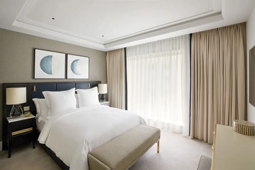 Ten Trinity, City of London: Double bedroom with navy headboard and sheer curtains
