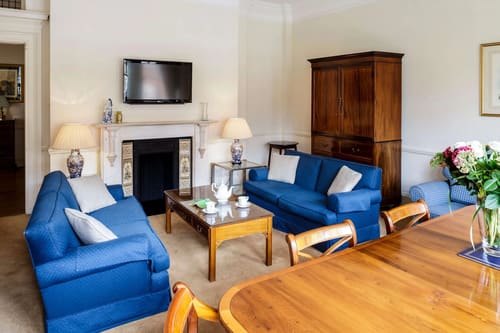 The Earls Court Road Apartments, Earl's Court: Living room with blue sofas and fireplace