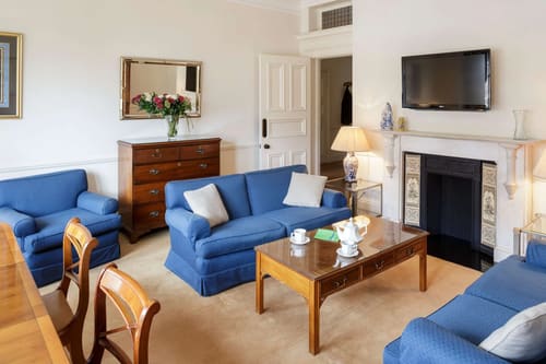 The Earls Court Road Apartments, Earl's Court: Living room with blue sofa and fireplace