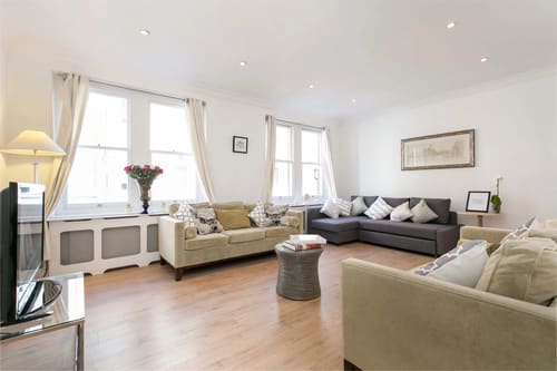 Nassau Street Chic, Fitzrovia: Living room with corner sofa and sash windows