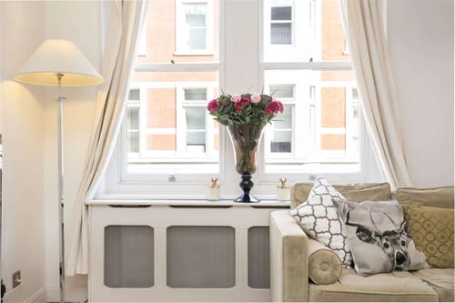 Nassau Street Chic, Fitzrovia: Window seat with flowers and radiator cover