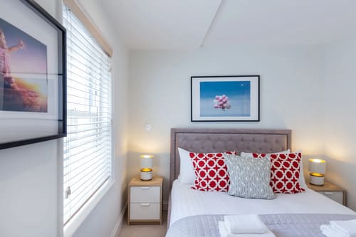 Floral Street Apartments, Covent Garden: Double bedroom with red patterned cushions