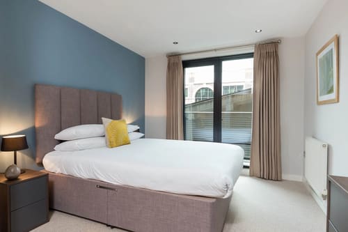 Waterloo Apartments, Waterloo: Double bedroom with blue wall and tall headboard