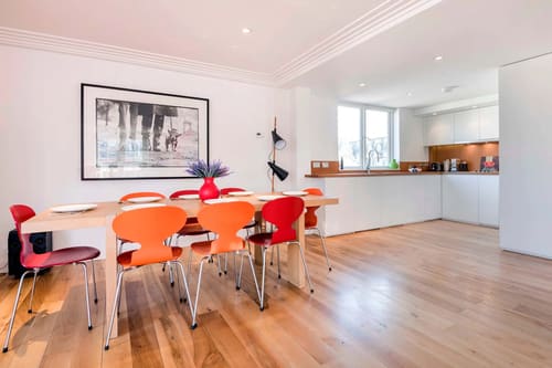 Covent Garden 3 bedroom, Covent Garden: Dining table with orange chairs and open kitchen