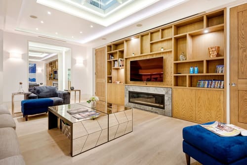 3-bedroom house near High St Kensington, Kensington: Living room with built-in shelving, fireplace and TV