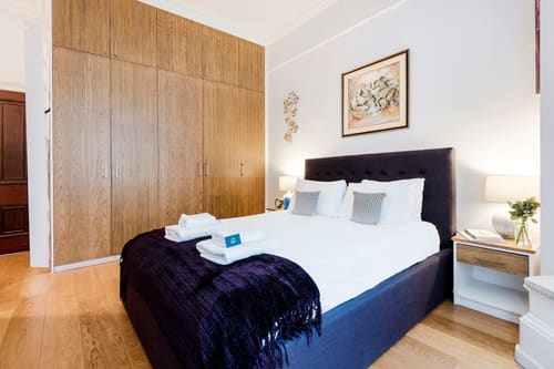Mayfair 1 bedroom near Green Park, Mayfair: Bedroom with wood-panelled wall and navy throw
