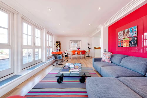 Covent Garden 3 bedroom, Covent Garden: Living room with red wall, grey sofa and striped rug