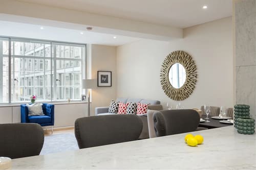The Strand Apartments, Covent Garden: Living room with sunburst mirror and blue armchair