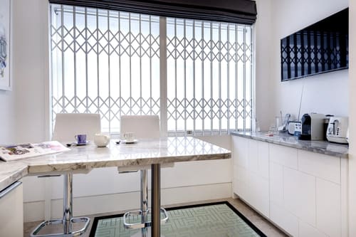 3-bedroom house near High St Kensington, Kensington: Breakfast bar with stools by a gated window