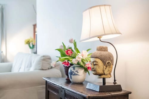 Central Mayfair 2 bedroom, Mayfair: Table lamp and Buddha head beside the sofa