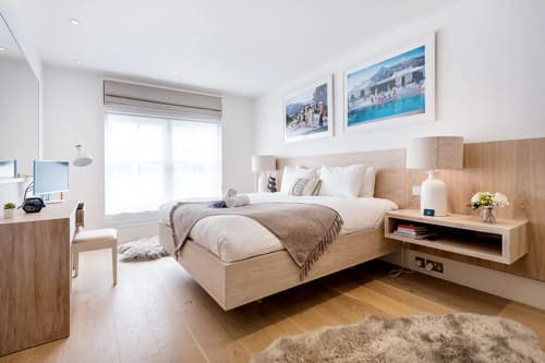 3-bedroom house near High St Kensington, Kensington: Double bedroom with pale wood bed and framed photographs