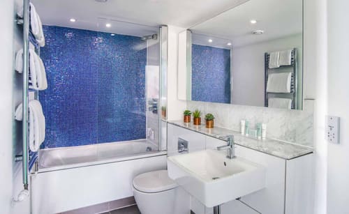 Lancaster Gate Apartments, Paddington: Bathroom with blue mosaic wall and bath