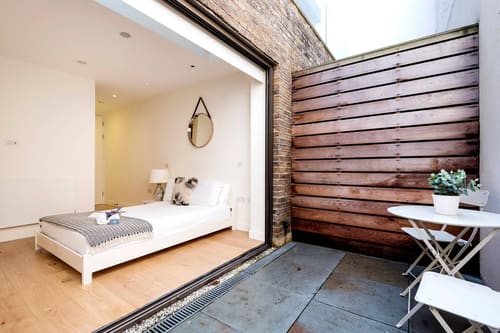 Fitzrovia 2 bedroom near Oxford Street, Fitzrovia: Bedroom opening onto a timber-clad courtyard