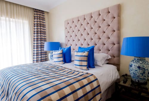 Hertford Street Residences, Mayfair: Bed with tall buttoned headboard and striped throw