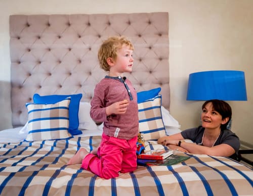 Hertford Street Residences, Mayfair: Child playing on a bed with striped cushions