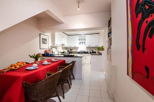 Central Mayfair 2 bedroom, Mayfair: Dining table with red cloth and kitchen beyond