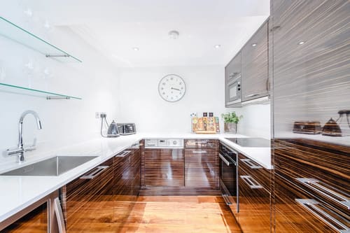Bayswater Garden Square Apartments, Kensington: Kitchen with wood-grain units and wall clock