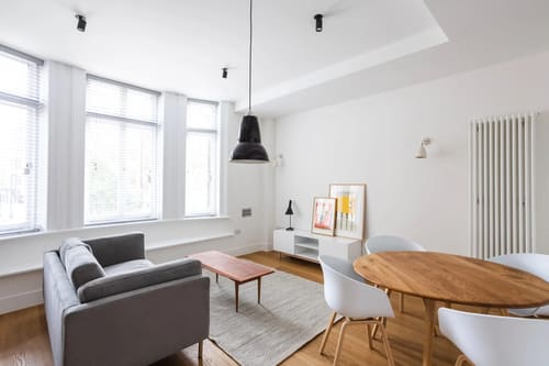 Blandford Street Apartments, Marylebone: Living room with grey sofa and round dining table