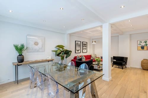Hyde Park Gate, Kensington: Glass dining table with ghost chairs and red sofa