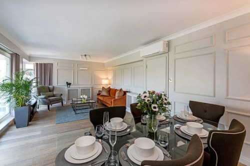 Hyde Park Gate, Kensington: Dining table laid for four with living area beyond
