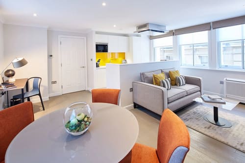 Calico House, East London: Living room with grey sofa and orange chairs