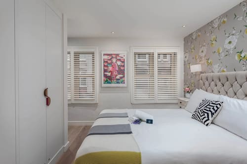 Covent Garden 2 bedroom near Opera House, Covent Garden: Twin beds with shutters and floral wallpaper