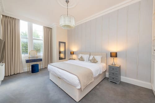 Hertford Street, Mayfair: Double bedroom with panelled wall and pendant light