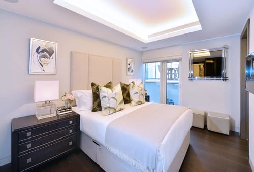 Duke St, W1K, Mayfair: Double bedroom with upholstered headboard and balcony doors