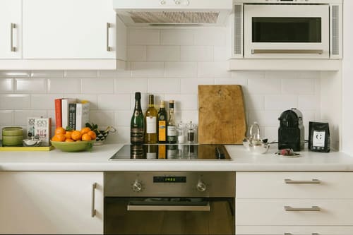 The Little Venice Apartments, Little Venice: Kitchen hob with white tiles and wine bottles