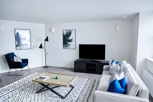 The Shoreditch Warehouse Apartments, East London: Living room with white sofa and patterned rug